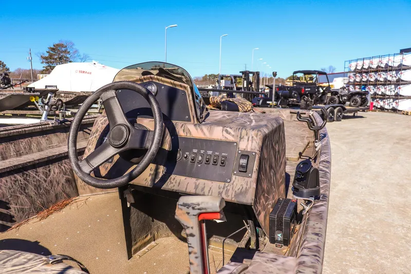 Slide: The Image of 2024 G3 Gator Tough 17 SC boat with camo design, steering wheel, and control panel. - 8