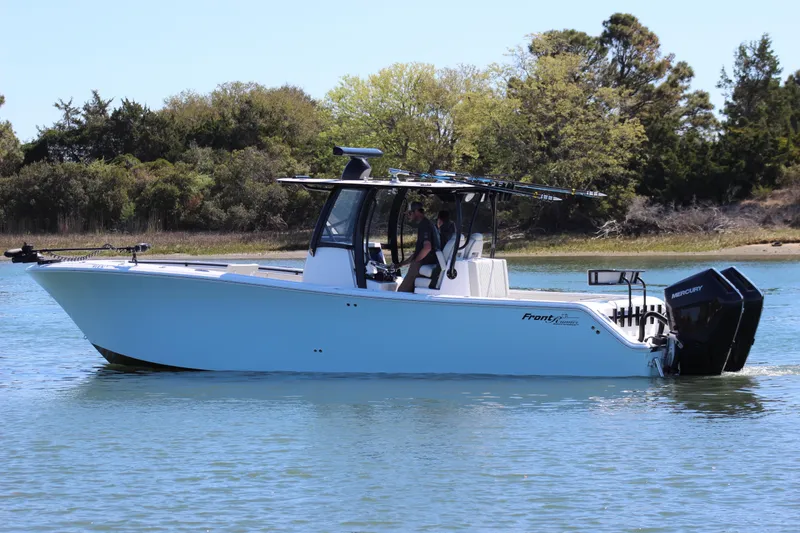 The Image of 2024 Front Runner 33 Center Console boat cruising on calm water near a sandy shoreline. - 0