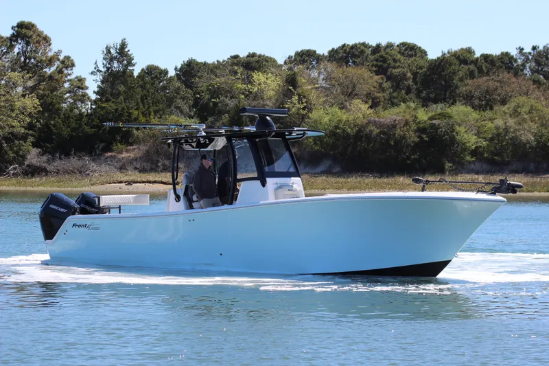 Slide: The Image of 2024 Front Runner 33 Center Console boat interior with luxurious seating on calm water. - 10