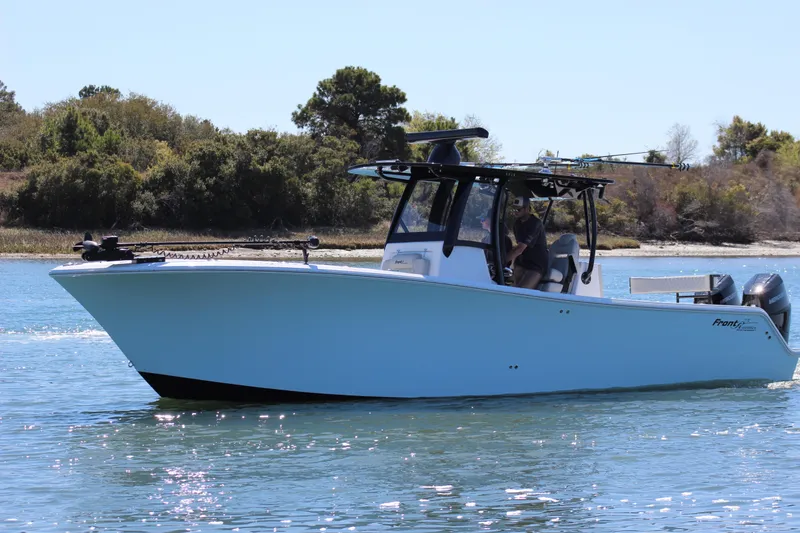 Slide: The Image of 2024 Front Runner 33 Center Console boat cruising on water with twin engines. - 2