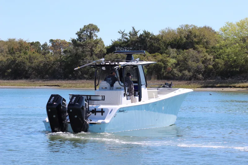 Slide: The Image of 2024 Front Runner 33 Center Console boat cruising on water, scenic background. - 7