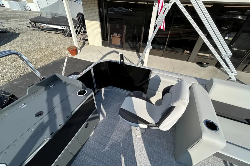 Slide: The Image of 2026 Harris Cruiser 210 boat interior with seating and control panel, docked outdoors. - 10