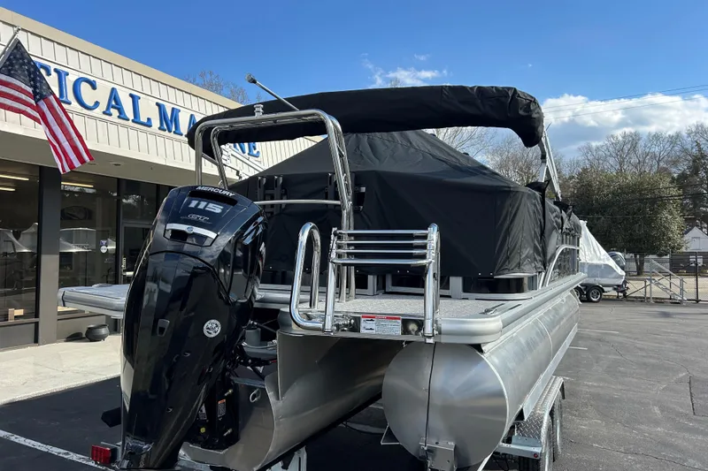 Slide: The Image of 2026 Harris Cruiser 210 pontoon boat with Mercury 115 engine at a marine dealership. - 25