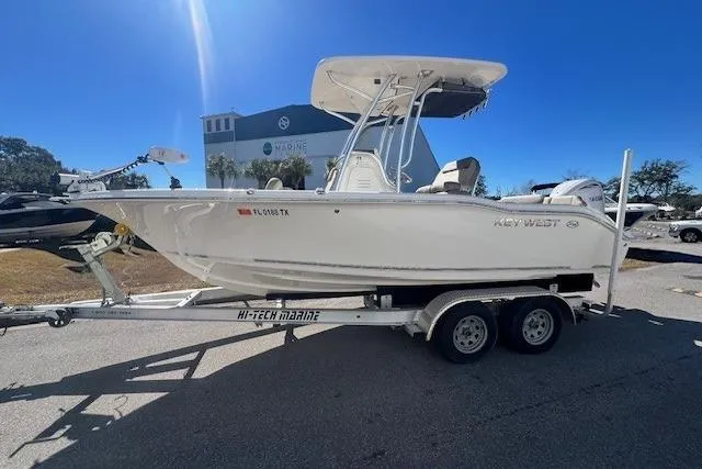 The Image of 2024 Key West 219 FS boat on trailer, parked outdoors under clear sky. - 1