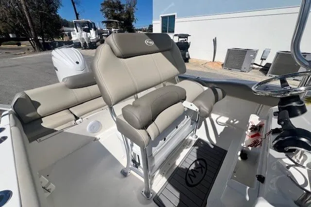 Slide: The Image of 2024 Key West 219 FS boat interior with cushioned seating and steering console. - 11