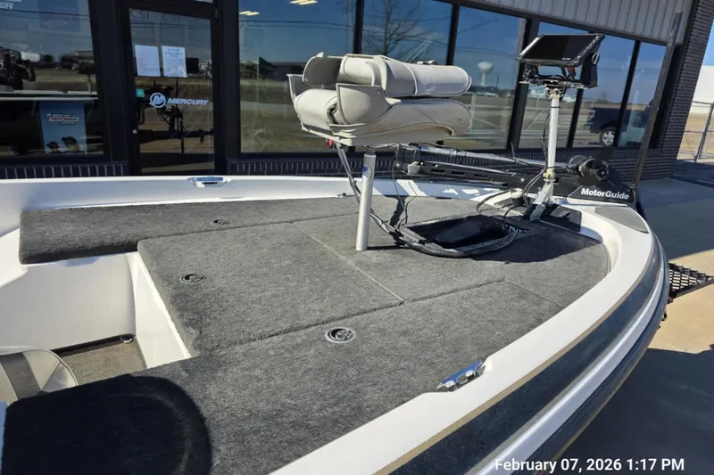 Slide: The Image of 2000 Skeeter SX180 boat with MotorGuide trolling motor and seating, displayed outdoors. - 12