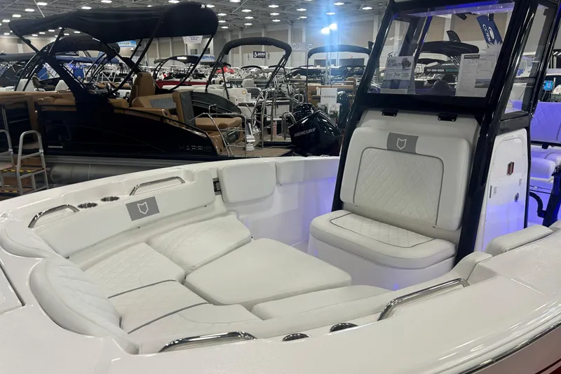 Slide: The Image of 2026 Sea Fox 228 Commander boat interior with white seating at a boat show. - 9
