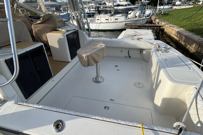 Slide: The Image of 2003 Carolina Classic 28 boat interior with covered seating and storage, docked at marina. - 10