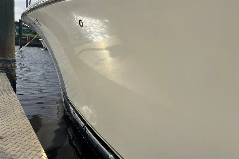 Slide: The Image of 2003 Carolina Classic 28 boat docked, reflecting sunlight on calm water. - 15