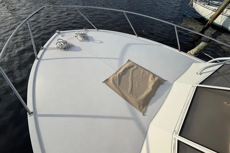 Slide: The Image of Bow of 2003 Carolina Classic 28 boat with railing and rope on calm water. - 16