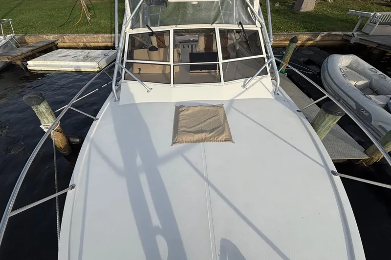 Slide: The Image of 2003 Carolina Classic 28 boat docked, featuring spacious deck and cabin area. - 17