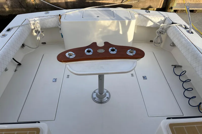 Slide: The Image of 2003 Carolina Classic 28 boat deck with fishing rod holders and cushioned seating. - 20