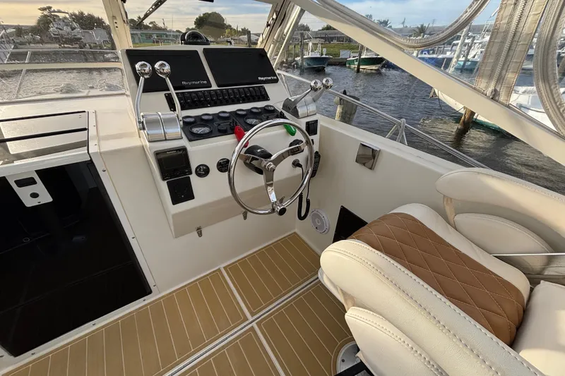 Slide: The Image of 2003 Carolina Classic 28 boat helm with steering wheel and control panel. - 24