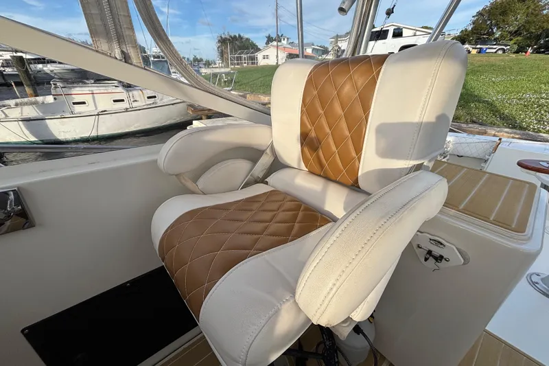 Slide: The Image of Luxurious leather seat on a 2003 Carolina Classic 28 boat, docked near other vessels. - 25