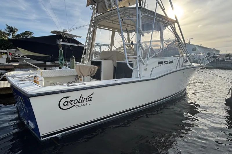 Slide: The Image of 2003 Carolina Classic 28 boat docked at marina under a cloudy sky. - 3