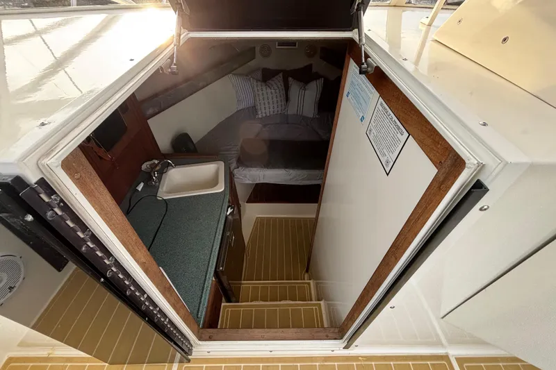 Slide: The Image of Interior view of 2003 Carolina Classic 28 boat cabin with bed and kitchenette. - 33