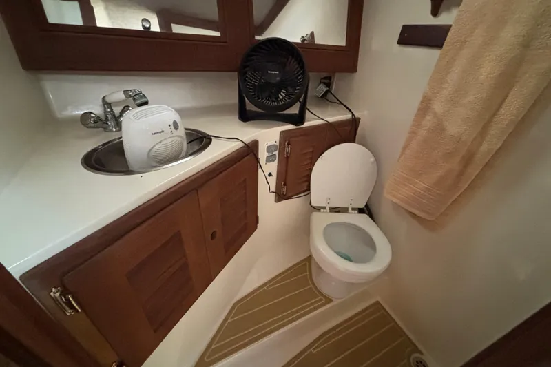 Slide: The Image of 2003 Carolina Classic 28 boat bathroom with sink, toilet, and fan. - 37