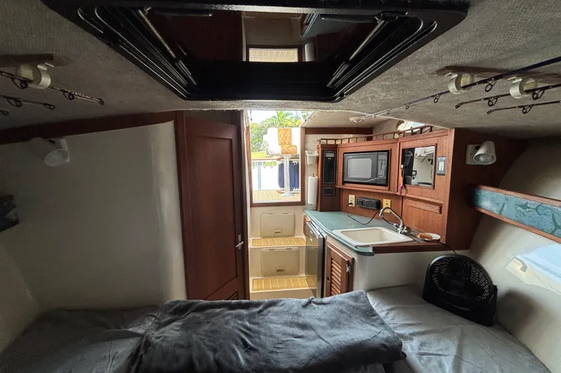 Slide: The Image of Interior of a 2003 Carolina Classic 28 boat with kitchenette and cozy sleeping area. - 38