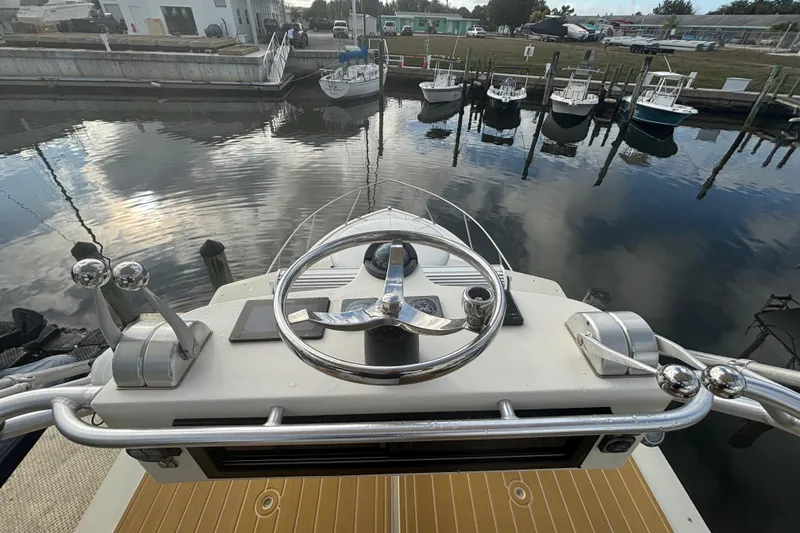 Slide: The Image of Helm of a 2003 Carolina Classic 28 in a marina. - 44