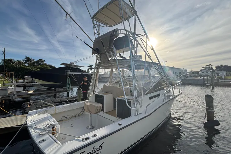Slide: The Image of 2003 Carolina Classic 28 boat docked at marina under a bright sky. - 5