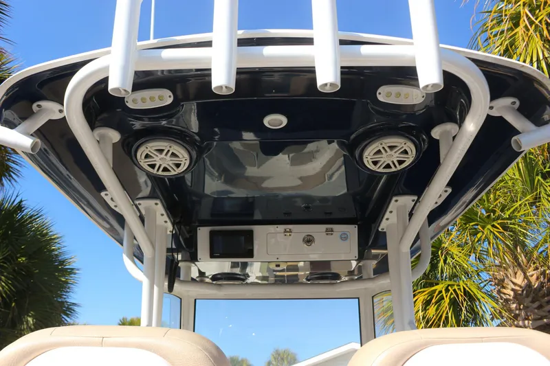 Slide: The Image of 2020 Sportsman Masters 267OE Bay Boat T-top with speakers and rod holders, under clear blue sky. - 15