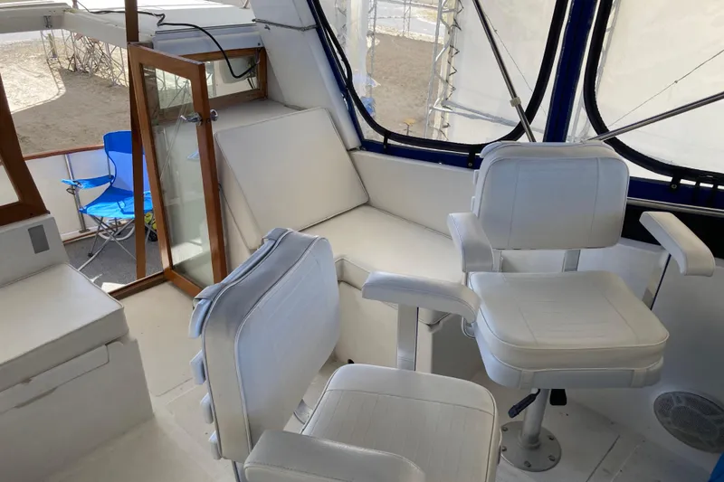 Slide: The Image of 1986 Heritage East Sundeck interior with white seating and open door, showcasing nautical design. - 11