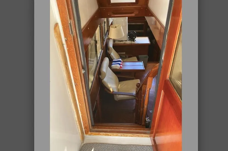 Slide: The Image of Interior view of 1986 Heritage East Sundeck yacht, featuring cozy seating and wooden finishes. - 20