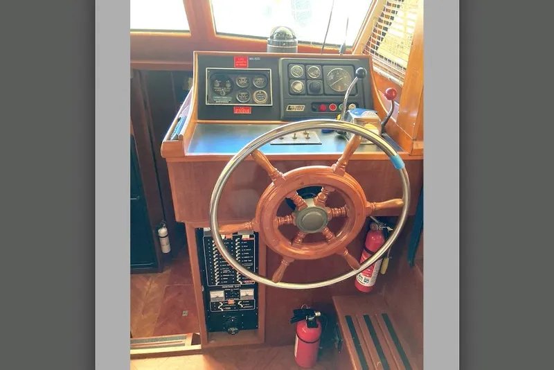 Slide: The Image of 1986 Heritage East Sundeck helm with wooden wheel and control panel. - 22