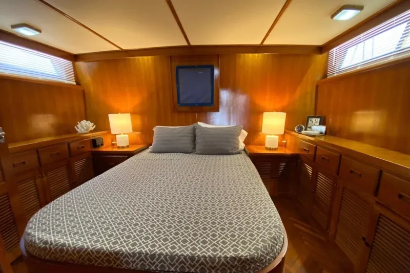 Slide: The Image of Luxurious 1986 Heritage East Sundeck yacht bedroom with wood paneling and cozy lighting. - 28