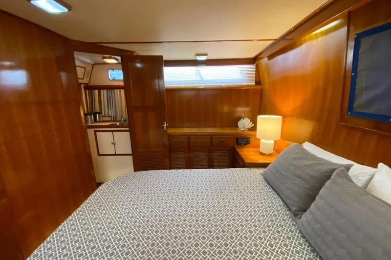 Slide: The Image of 1986 Heritage East Sundeck interior with cozy bedroom, wooden paneling, and soft lighting. - 29