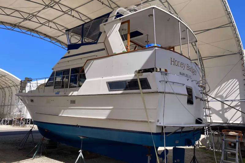 Slide: The Image of 1986 Heritage East Sundeck yacht, "Honey Badge," docked in a covered marina. - 3