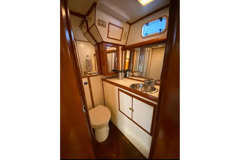 Slide: The Image of 1986 Heritage East Sundeck yacht bathroom with wood accents, sink, and toilet. - 33