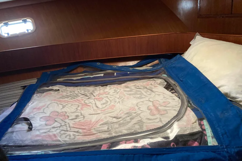 Slide: The Image of 1986 Heritage East Sundeck cabin interior with floral bedding and blue cover. - 37