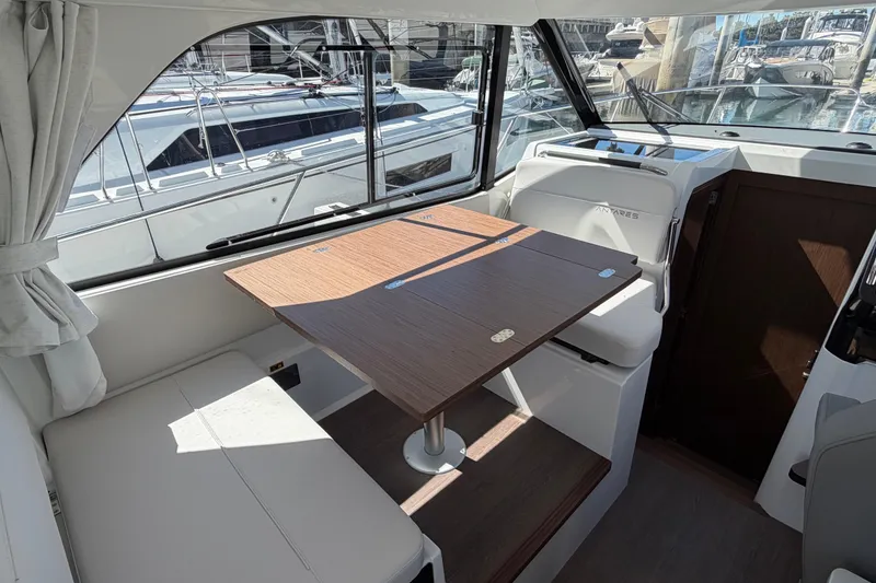 Slide: The Image of Interior of 2026 Beneteau Antares 9, featuring a cozy dining area with wooden table. - 22