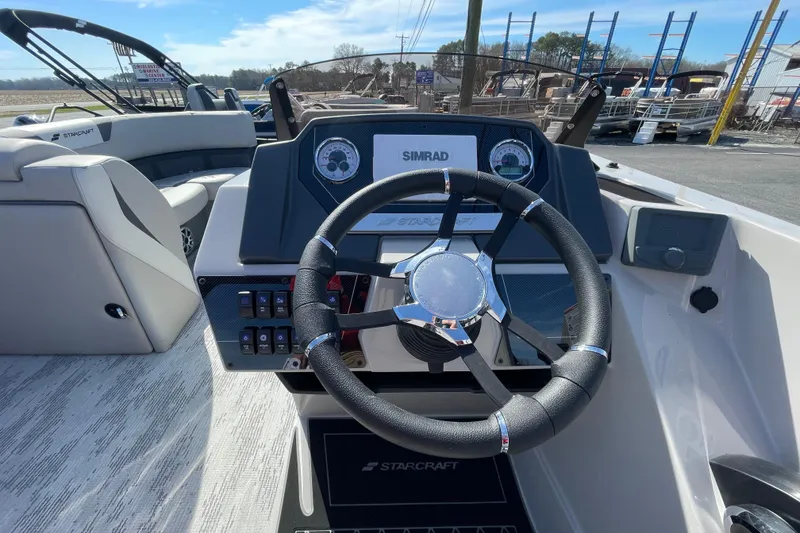 Slide: The Image of 2026 Starcraft SLS 1 boat dashboard with steering wheel and Simrad display. - 8