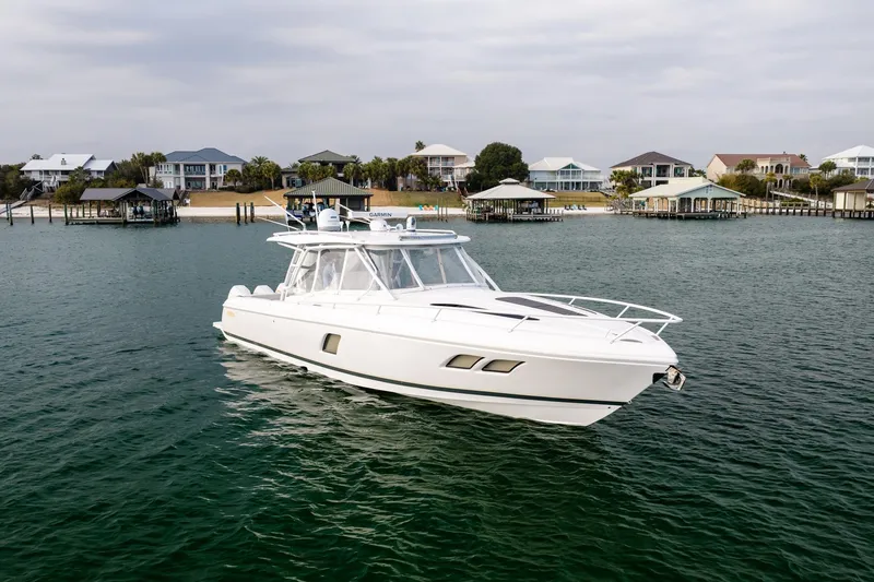 Slide: The Image of 2020 Intrepid 407 Cuddy boat cruising near waterfront homes. - 13