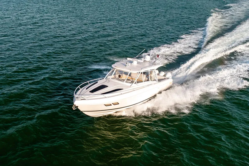 Slide: The Image of Aerial view of 2020 Intrepid 407 Cuddy boat cruising on green ocean waters. - 15