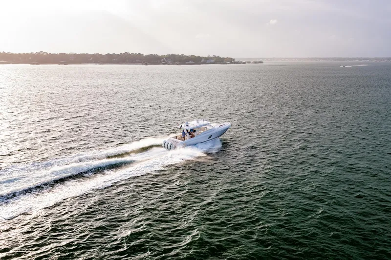 Slide: The Image of 2020 Intrepid 407 Cuddy cruising on open water, creating a dynamic wake. - 16