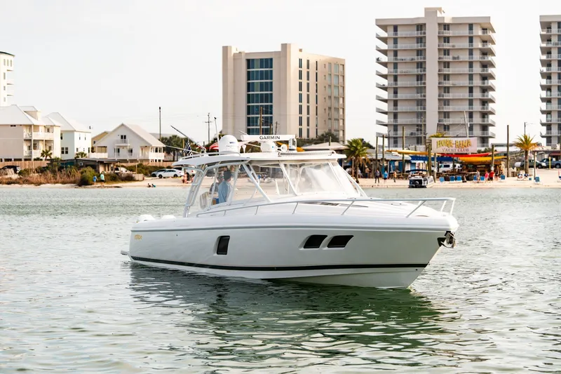 Slide: The Image of 2020 Intrepid 407 Cuddy boat cruising near a beachside cityscape. - 3