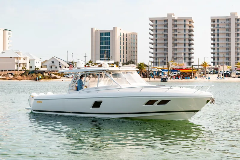 Slide: The Image of 2020 Intrepid 407 Cuddy boat on water near beachfront buildings. - 4