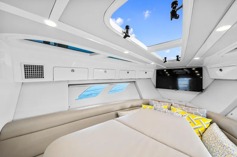 Slide: The Image of 2020 Intrepid 407 Cuddy interior with skylights, modern seating, and vibrant cushions. - 40