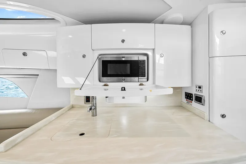 Slide: The Image of 2020 Intrepid 407 Cuddy interior with modern kitchenette and microwave. - 44