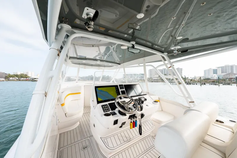 Slide: The Image of 2020 Intrepid 407 Cuddy boat interior with modern helm and waterfront view. - 59