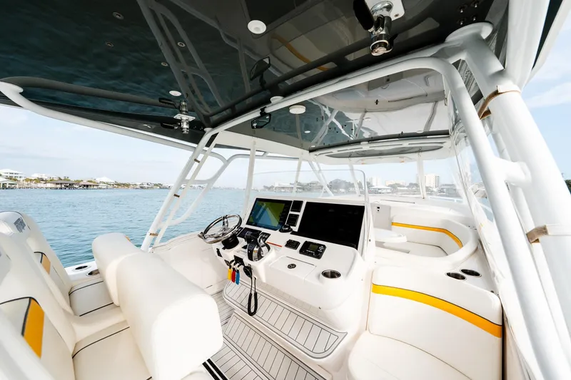 Slide: The Image of 2020 Intrepid 407 Cuddy boat interior with modern helm and seating on open water. - 60