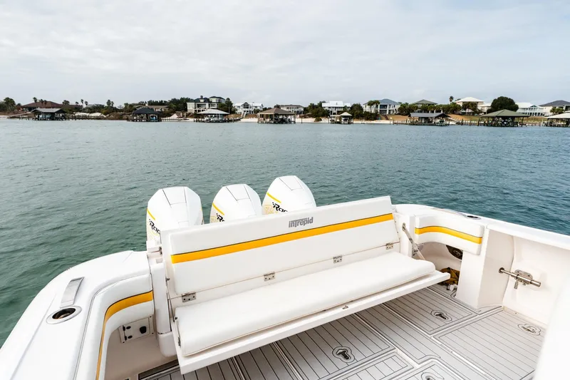 Slide: The Image of 2020 Intrepid 407 Cuddy boat with triple engines, docked near coastal homes. - 62