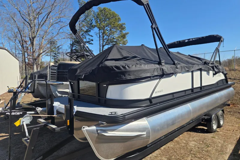 Slide: The Image of 2026 Godfrey Monaco 255 QS pontoon boat on trailer, covered and parked outdoors. - 4