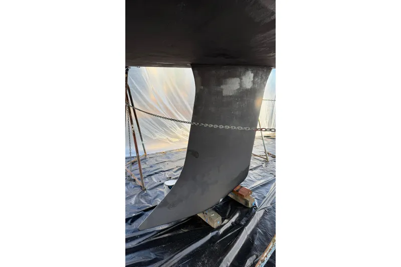 Slide: The Image of Keel of 2004 Beneteau First 36.7 sailboat under maintenance, supported by chains and blocks. - 31
