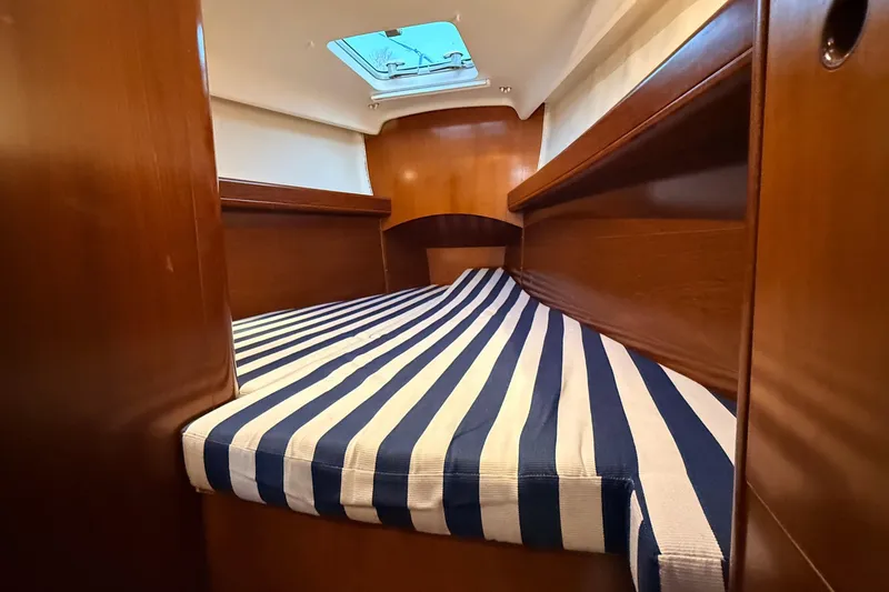 Slide: The Image of Cozy cabin interior of 2004 Beneteau First 36.7 with striped bedding. - 6