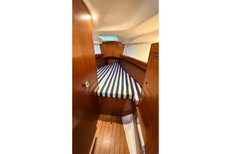 Slide: The Image of 2004 Beneteau First 36.7 cabin interior with striped bedding and wooden finish. - 7