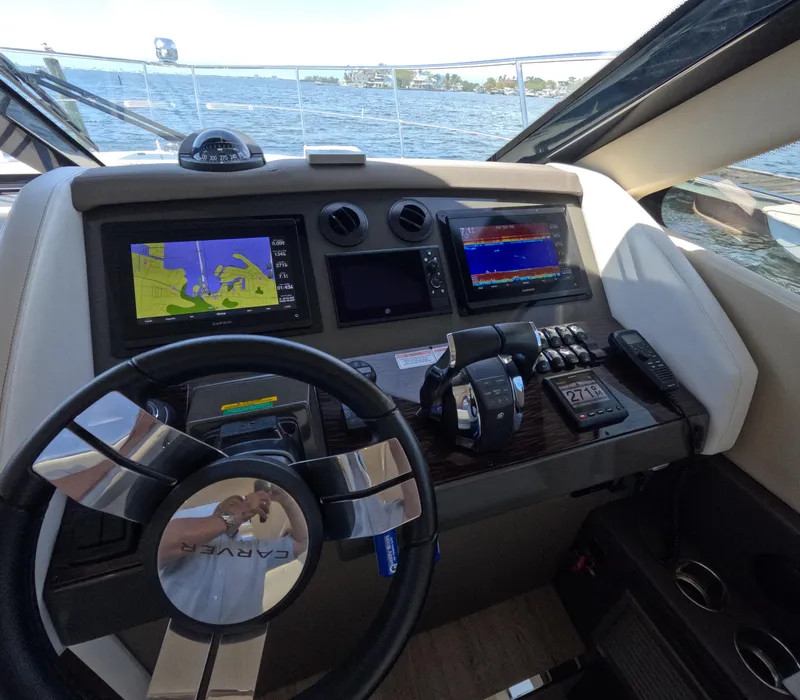 Slide: The Image of Helm of 2019 Carver C37 Coupe with navigation screens and controls, overlooking water. - 11